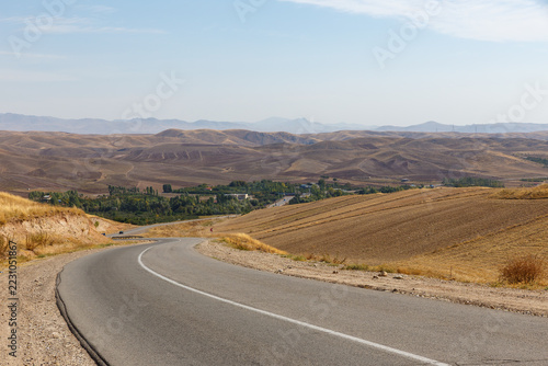 Obraz na plátně Curving asphalt road descending to green village valley in East Azerbaijan Provi