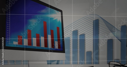 Computer screen displaying financial graphs and charts in modern office setting