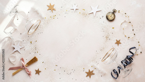 Luxury New Year Party Background with Gold Foil Paper Stars, Curled Midnight Blue Streamers, Champagne Confetti and Crystal Drinkware Arranged Around an Open Blush Center
