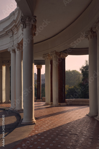 Obraz na plátně Serene curved colonnade at sunrise with long shadows on terracotta tiles, orname