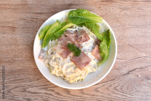 steamed spaghetti topping slice ham pork with dressing white truffle mushroom cream sauce with fresh cos lettuce salad on plate 