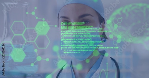 Posing clinician wearing blue scrubs and surgical cap in lab, with stethoscope, glassware