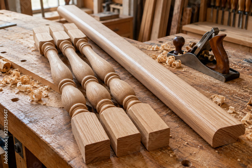 Milled wooden stair parts stacked at a joinery bench