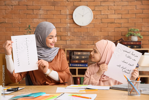 Arabic language learning, mother and daughter practicing reading and writing ...