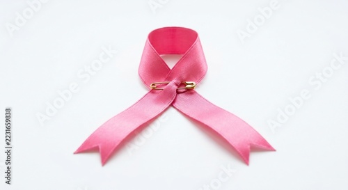 Pink ribbon symbol with gold safety pin on white background for health awareness campaign