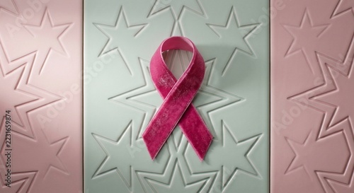 Pink velvet awareness ribbon centered on pastel geometric patterned background