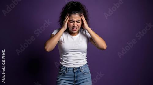 Young Woman Experiencing Severe Headache Pain Holding Her Temples.