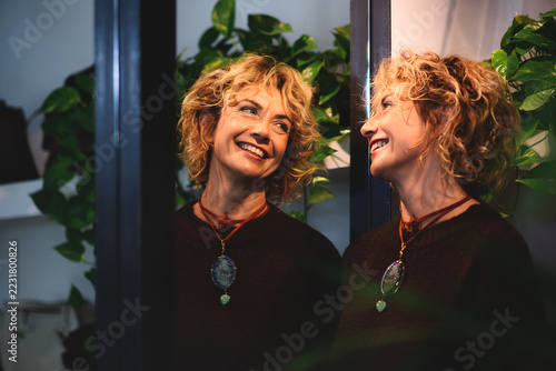 Fotografie Sharing happiness with oneself: conceptual portrait of a cheerful woman looking