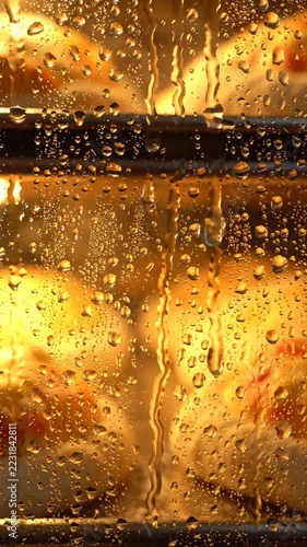 Buns rising in a warm oven seen through glass with condensation and glowing yellow light, closeup