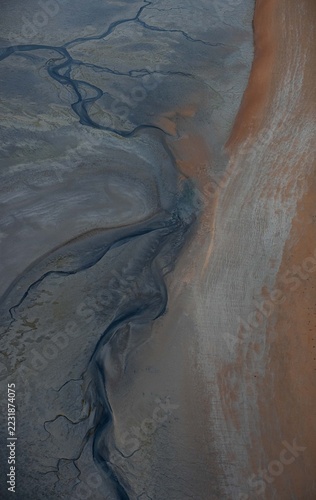 Branching Tidal Drainage Patterns Across Grey and Rust-Coloured Coastal Mudflats near Broome, Australia