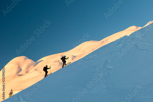 Backcountry skiers ascending snowy mountain slope