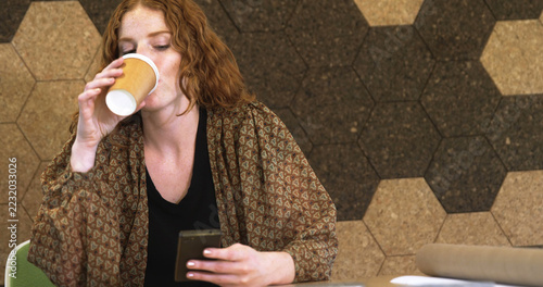 Obraz na plátně Young Caucasian woman enjoys a coffee break at the office