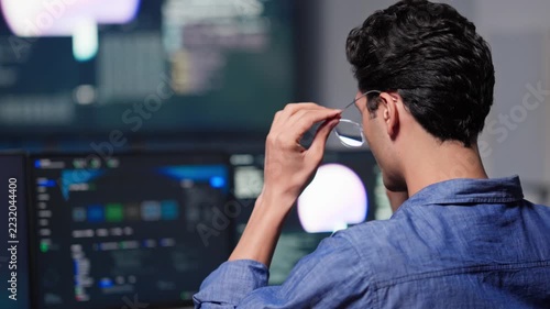 Programmer Working on Multiple Screens in Dark Modern Office at Night