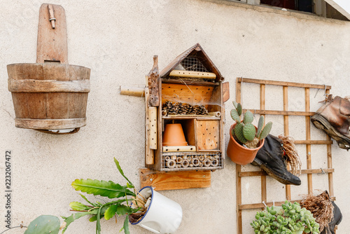 Wooden bug house and repurposed planters on a wall