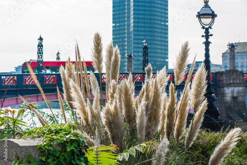 High-rise buildings, bridge over the Thames and red bus. London city life. 