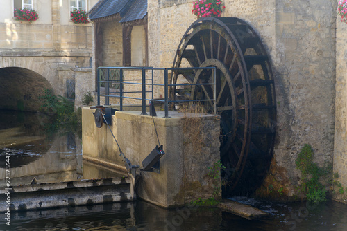 Idyllic scenery at French city of Bayeux with Aure River, water wheel and historic buildings on a sunny summer afternoon. Photo taken July 17th, 2026, Bayeux, Normandie, France.