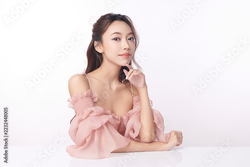 A beautiful young Asian woman with clean, fresh skin against a white background. Skincare, facial treatment, cosmetology, beauty, and spa. An elegant portrait of an Asian woman.