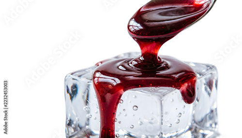 Macro shot of glossy ruby cherry syrup pouring over a block of clear ice, deep red liquid swirling smoothly, isolated on a white background.