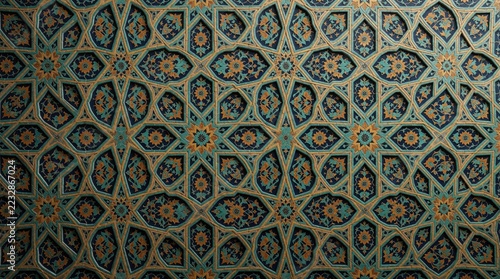 Intricate mosaic tile pattern with floral motifs. Colorful blue, gold geometric design features ornate ceramic ornaments on wall. Traditional Islamic art style shows detailed craftsmanship, symmetric