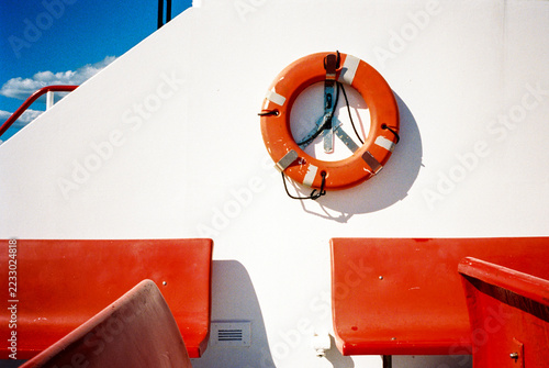 Red benches and life preserver on ferry boat