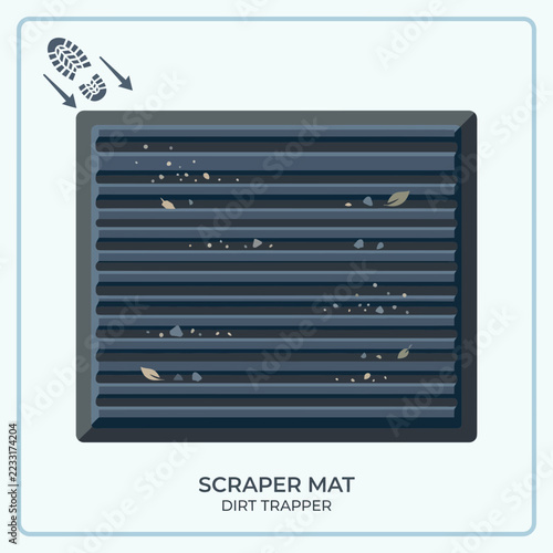 A dark gray scraper mat with dust and small debris on it.