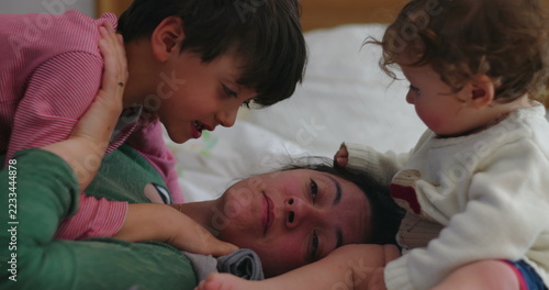 Obraz na plátně Toddler pulls mother's hair repeatedly while older brother competes for attentio