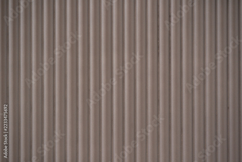 Fotografie Vertical fluted wall paneling texture in muted taupe brown, creating a modern linear ribbed architectural background