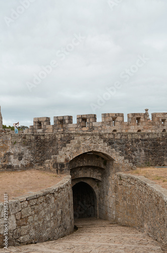 Obraz na plátně Ancient atone fortress entrance with medieval defensive walls, and a female tour
