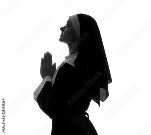 Fotografie Faith and spirituality, nun praying with hands together in silhouette, religious