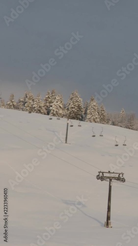 Vertical morning time-lapse footage of a ski resort and its snow-covered slope, showing the evolving mountain atmosphere and expansive alpine surroundings.