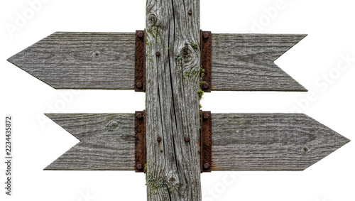 Weathered wooden directional signpost with two rustic arrow boards and rusty bolts
