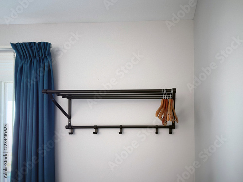 Obraz na plátně portemanteau avec des rideaux bleus devant un mur blanc.