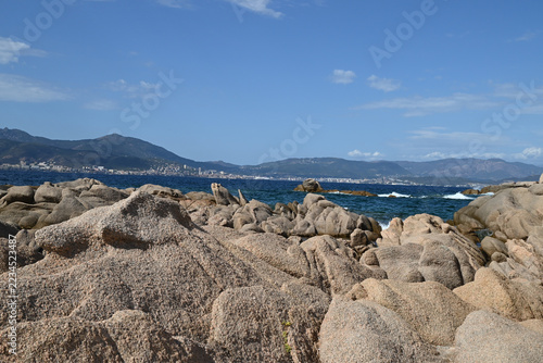 Rochers sur le littoral d'Isolella en Corse avec la ville d'Ajaccio au second plan