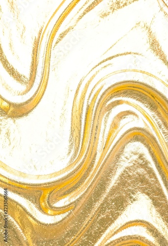 Abstract gold wave texture background with metallic foil swirl patterns and bright glowing white light reflections