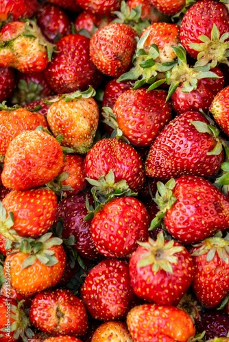 Macro close-up of fresh ripe red strawberries with green leaves, organic food.