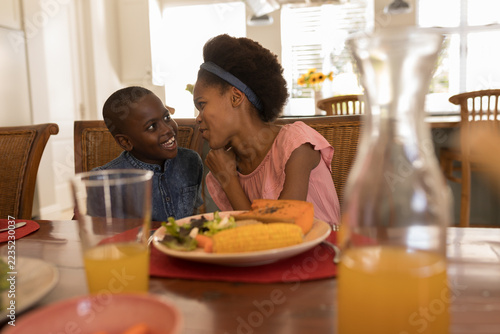 Siblings interacting with each other on dining table