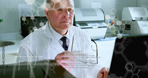 Image of computer language, hexagon and symbols over caucasian scientist working on computer