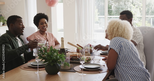 Friends enjoying lunch together at home, sharing laughter and conversation