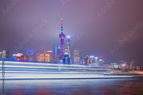 Photography Shanghai colorful skyline with motion speed light of passing ferry in the foregr