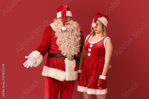 Fotografie Christmas stress and holiday burnout, Santa Claus and young woman in festive cos