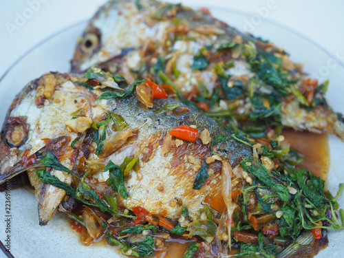 Stir-fried mackerel with holy basil sits on the plate; it looks appetizing, spicy, and delicious. This is a Thai dish I made.
