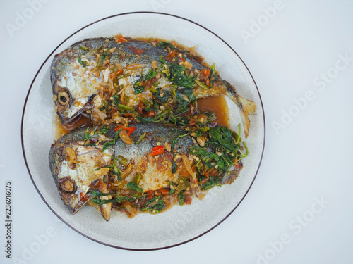 Stir-fried mackerel with holy basil sits on the plate; it looks appetizing, spicy, and delicious. This is a Thai dish I made.