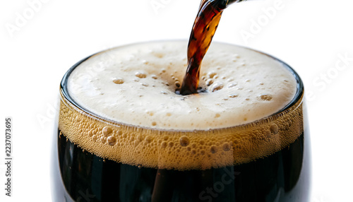 Macro of dark stout beer cascading in a glass, thick creamy nitrogen bubbles settling, on a white background.