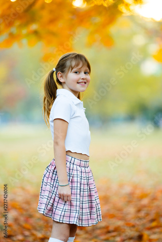 Autumn girl with leaves. Autumn kid outdoors. Bright autumn background. Happy autumn child.