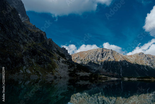 A mountain pond with reflecting peaks. The Black Pond below Rysy in the Tatra Mountains. Czarny Staw pod Rysami. Tatry Wysokie.